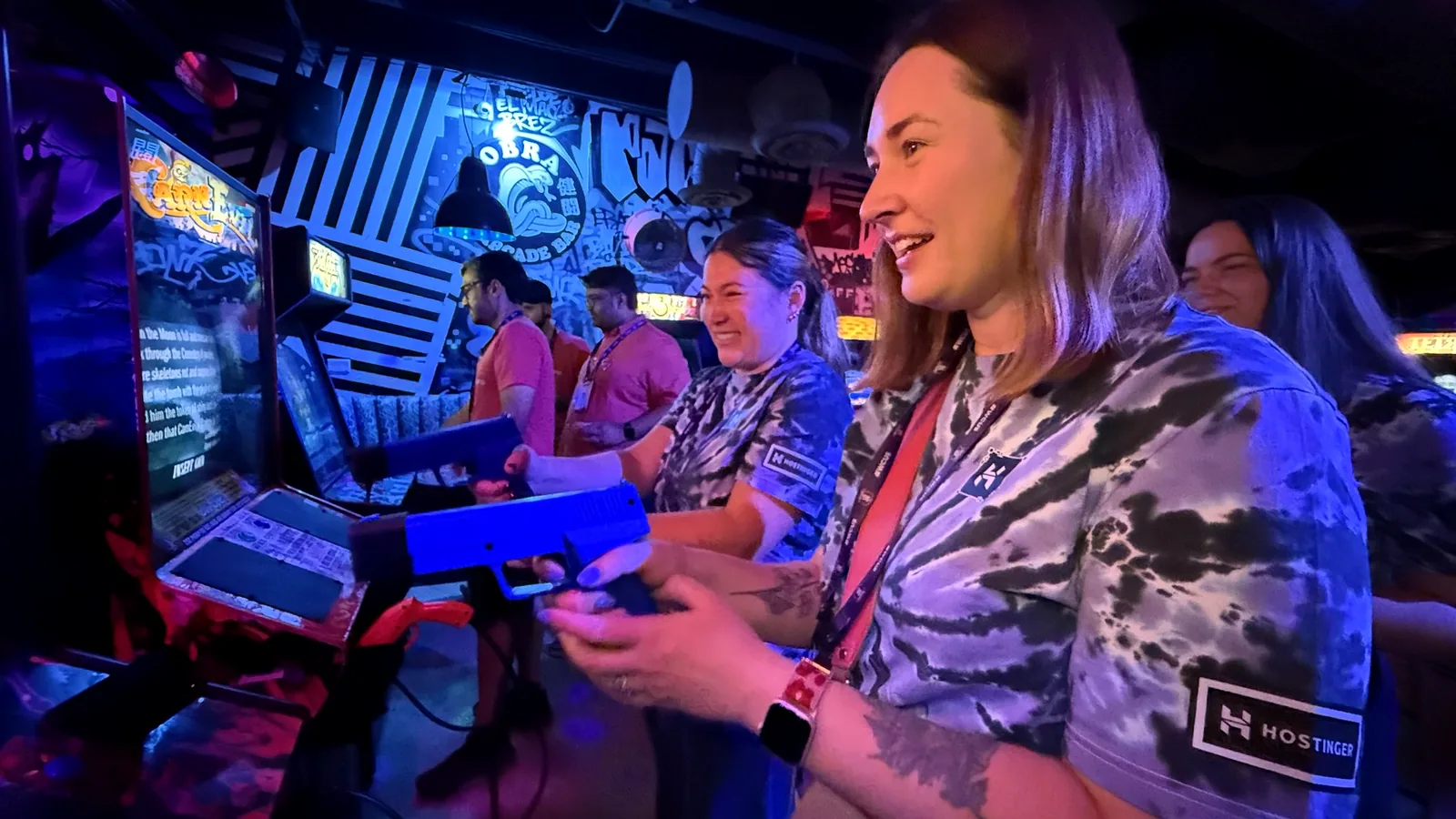 WordCamp US attendees playing an arcade game together at Cobra Arcade Bar.